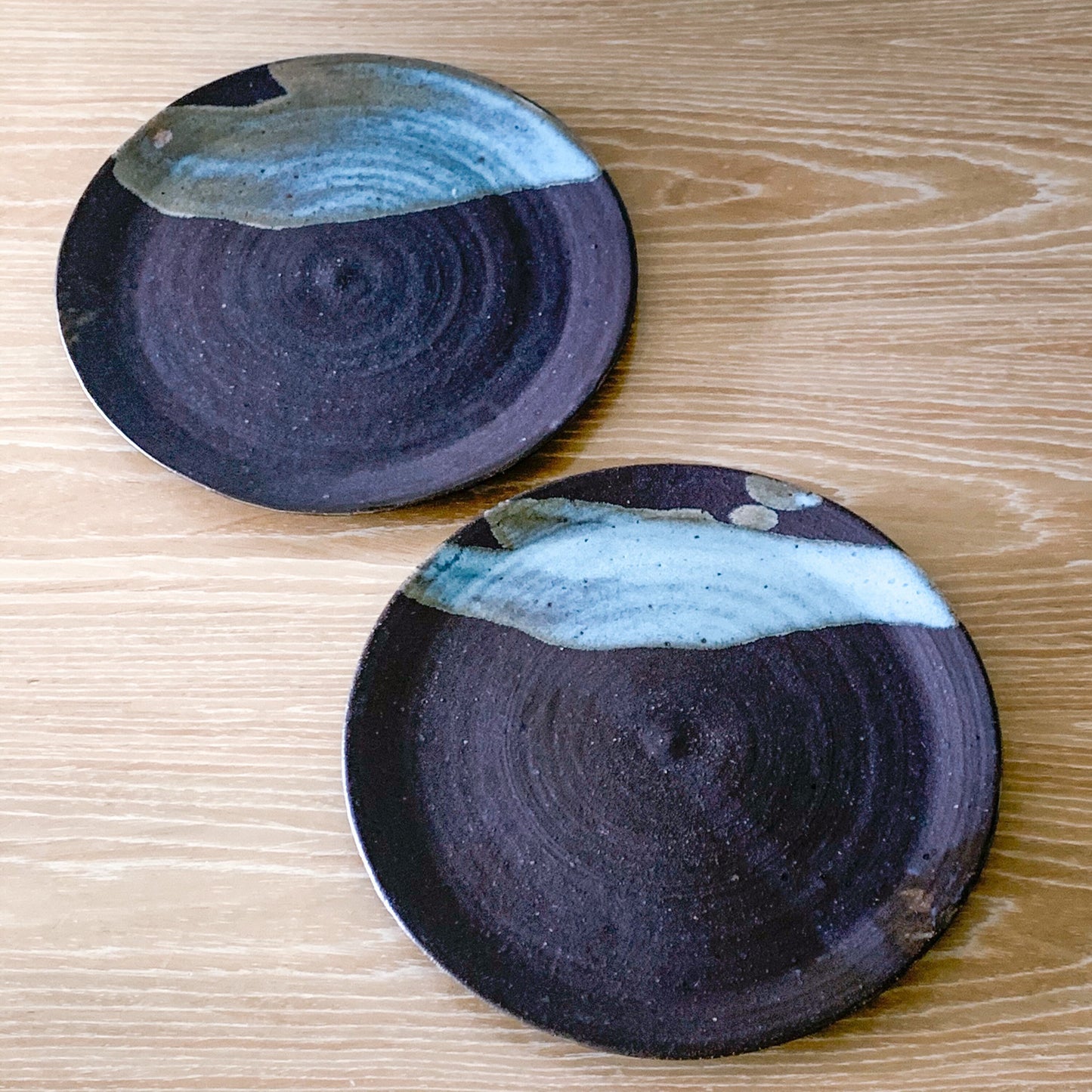 Pottery plate in matt brown color with shiny blue splash