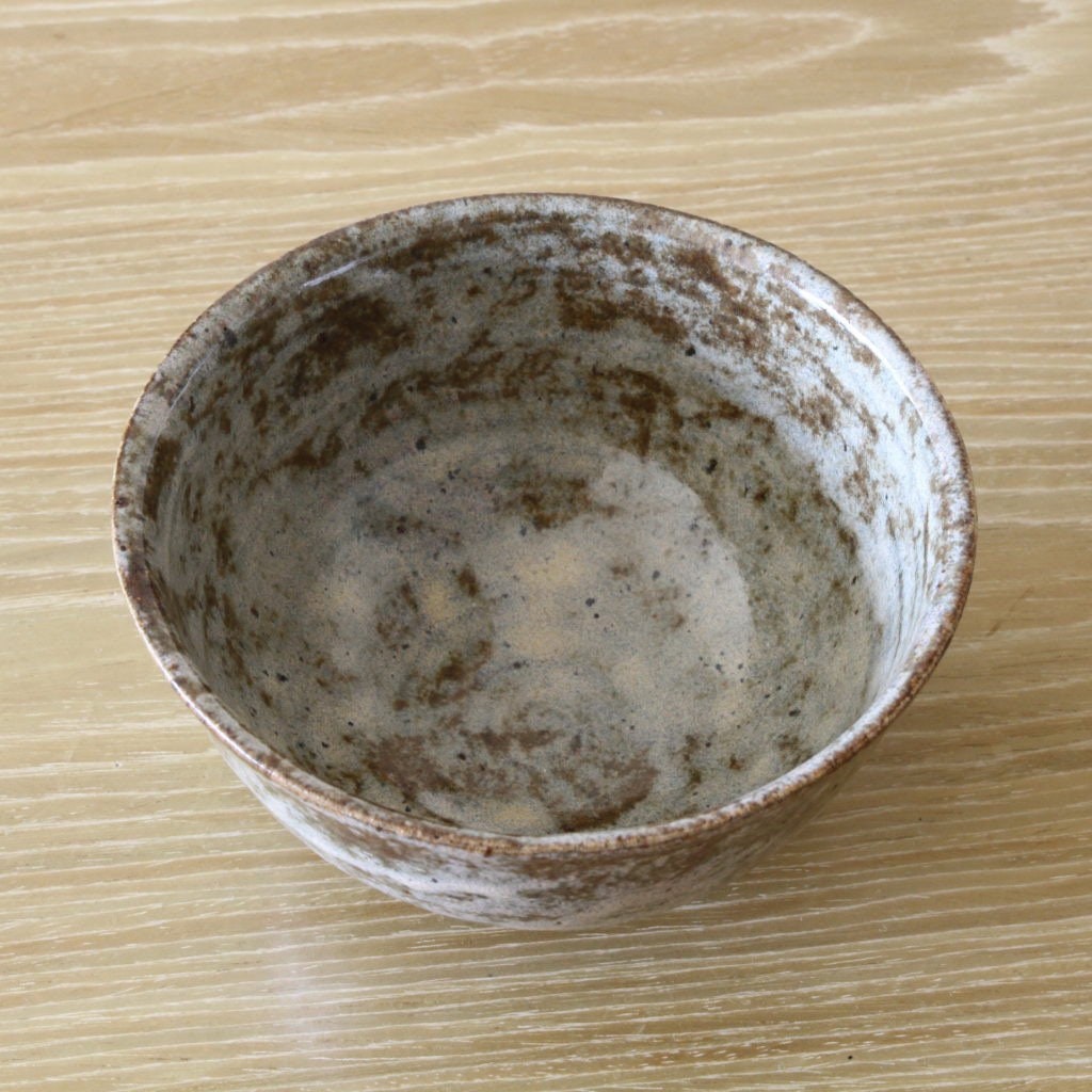 Pottery bowl in reddish brown color and dappled glaze
